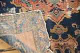 Antique Malayer rug corner reveals distressed navy pile and intricate hand-knotted foundation.