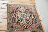 Antique Farahan Sarouk rug mat with plum and blue medallion, viewed at an angle, measuring 1'11