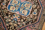 Close-up of the medallion and border on an antique Farahan Sarouk rug in blue, pink, and brown.