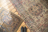 Antique Lavar Kerman rug featuring muted cochineal red and navy floral designs on light ground.
