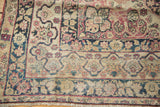 Antique Kerman rug's Safavid-inspired border design in cochineal red, sky blue, with visible wear.