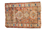 Antique Caucasian rug, distressed with geometric medallions, wine red, ivory, tattered ends.