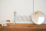 Antique Fleur De Lis Barber Mirror, round beveled glass with aged silver accordion mount, 8