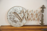 Fleur-de-lis mount and accordion arm of the barber mirror, showing aged silver paint.