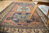 Vintage Persian Meshkin rug with octagonal medallions and dusty blush field featuring figures.