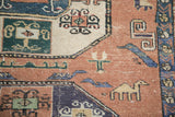 Vintage Meshkin rug detail: distressed dusty blush field, geometric camel, and rectilinear animal border.