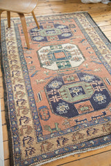 Vintage Meshkin rug: rectilinear border with repeating animals and dusty blush field.