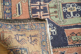 Rectilinear animal motifs on worn pile of vintage Meshkin rug, revealing woven foundation.