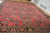 Distressed Lilihan rug's dark navy border with intricate palmettes and blossoming burgundy field.