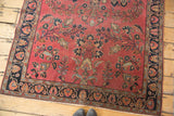 Distressed Lilihan rug's fringed end, with a rich burgundy field and navy floral border.