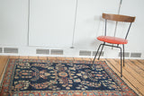 Antique Farahan Mohajeran Sarouk rug showcasing dark blue field and blush rose palmette border.