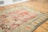 Tribal geometric patterns and Laleh Abbasi border on an antique prayer Caucasian rug with distressed patina.