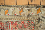 Antique Caucasian rug border with geometric tribal motifs in ivory, tangerine, and time-softened charcoal.