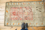 Bottom border of distressed antique Caucasian rug with tangerine and ivory geometric motifs.