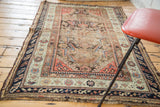 Antique Turkish Demirci rug side detail: worn pile, geometric borders, muted coral, cream, and navy.
