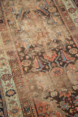Antique Demirci rug's worn field with abstract sickle herati motifs in terracotta, blue, and brown.