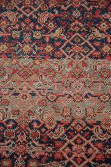 Tight herati motif on antique Malayer rug, with dark blue, striated greige abrash, red, and blush.