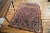 Corner detail of antique Malayer rug: herati motif, dark blue field, patinated red borders.