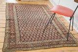Antique Kurdish rug corner, with time-softened rainbow boteh motifs and detailed borders.