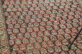 Variegated rainbow boteh motifs and textured pile define this antique Kurdish rug.