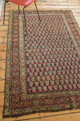 Antique Kurdish rug corner detail with rainbow boteh pattern and worn fringe.