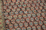 Intricate hand-knotted boteh pattern and border in rich rainbow colors on an antique Persian Kurdish rug.