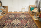Angled room view of the late 19th-century Lavar Kerman carpet's repeating paneled pattern.