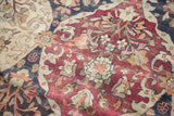 Storied, hand-knotted texture of an antique Lavar Kerman's red, navy, and ivory floral design.