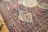 Detailed corner view of an antique Lavar Kerman's decorative, time-softened floral pattern.