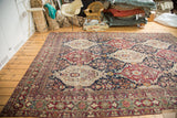 An antique collector's Lavar Kerman carpet at an angle, showing its complex multi-paneled floral design.