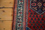Original selvage and intricately patterned border of the Engelas rug in red, blue, and ivory.