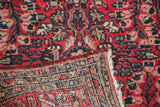 Hand-knotted vintage Lilihan rug corner, showing cherry red floral pile, original selvage, and fringe.
