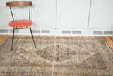 Antique Lavar Kerman rug's scalloped medallion on dark ground with distressed field.