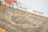 Distressed mil fleur patterns, faded colors, and visible texture of the antique Lavar Kerman rug.
