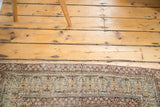 Antique Lavar Kerman rug border with intricate mil fleur and cyprus tree style vines, faded tones, and distressed pile.