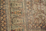 Intricate border of antique distressed Lavar Kerman rug, showing scrolling vines and time-softened floral motifs.