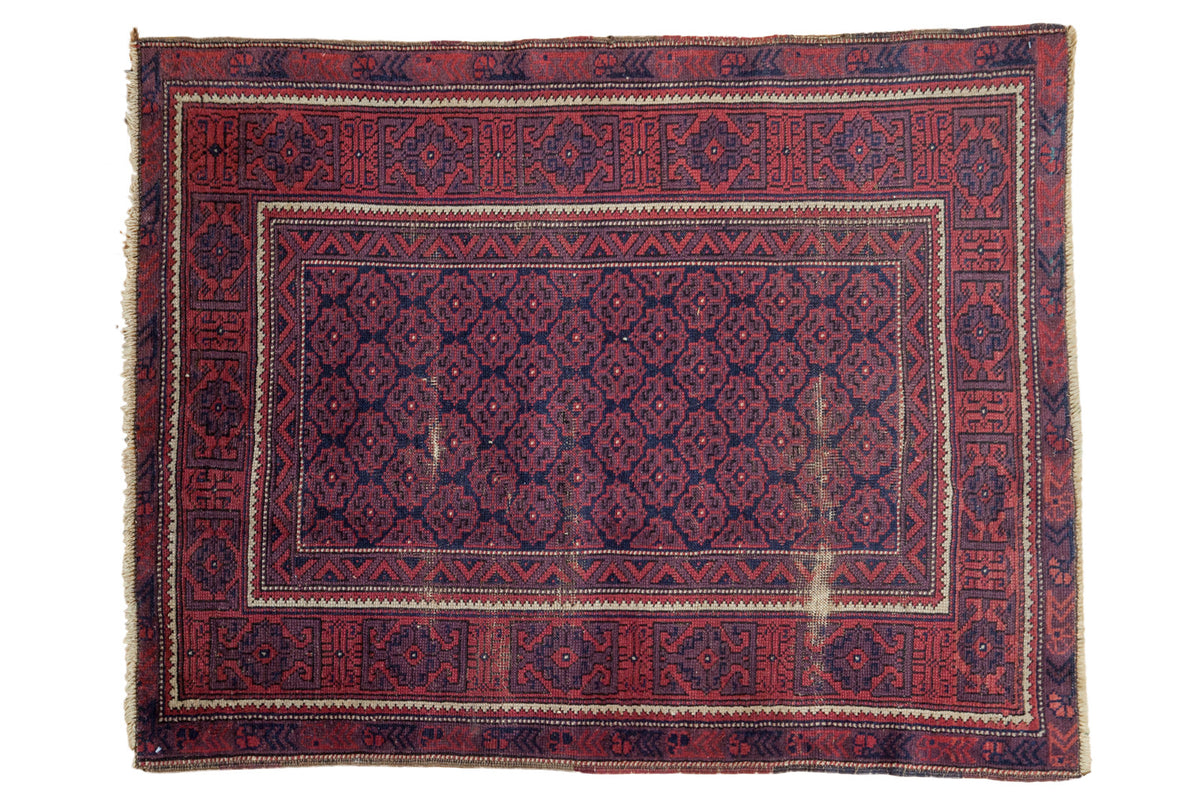 Bold vintage hand-knotted Belouch rug with allover navy geometric floral field, brick red border, and localized wear, 3'8" x 4'9".