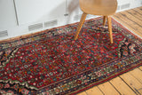 Vintage Borchalou rug's rich cherry red field and intricate Herati pattern with spandrels.