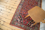 Vintage Borchalou rug corner with navy blue spandrel, detailed herati pattern, and natural fringe.