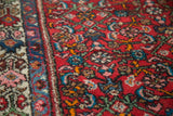 Intricate Herati design in rose, mint, aqua, and tangerine on a cherry red Borchalou rug.