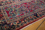 Hand-knotted vintage Sarouk fragment with floral motifs in cherry red, navy, and gem tones.