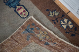 Detail of hand-knotted construction, secured edge, and floral bronze border on antique Chinese Art Deco rug.