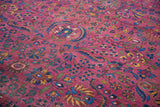 Distressed texture of a vintage Meshed rug, showcasing plum scrolling vines and blossoming florals.