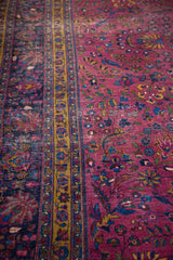 Distressed vintage Meshed rug with burgundy field, gold stripe, and blue floral motifs.
