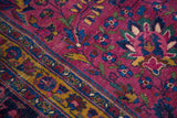 Distressed vintage Persian Meshed rug, burgundy plum field, blue and gold scrolling floral patterns, multi-band border.