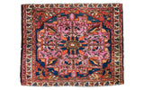 Antique Lilihan square mat with softened raspberry, bold tangerine, deep blue floral motifs.