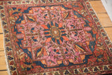Detailed view of antique Lilihan rug: softened raspberry field, tangerine, and navy floral motifs.
