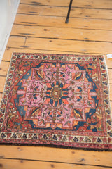Intricate floral pattern and navy border on antique Lilihan rug with softened raspberry tones.