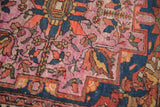 Antique Lilihan rug's delicate floral patterns in softened raspberry, tangerine, and deep blue.