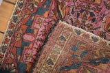 Folded antique Lilihan rug reveals its hand-knotted foundation and softened raspberry pile.